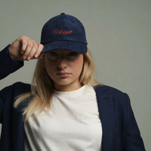 woman wearing navy blue corduroy baseball cap