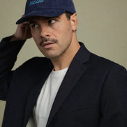 Man wearing a navy blue corduroy baseball cap