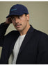 Man wearing a navy blue corduroy baseball cap