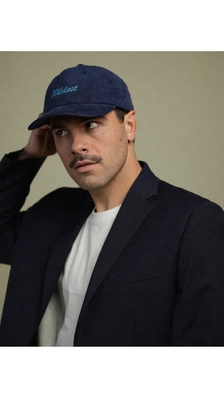 Man wearing a navy blue corduroy baseball cap