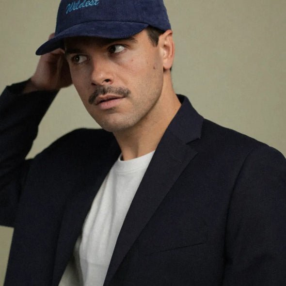 Man wearing a navy blue corduroy baseball cap