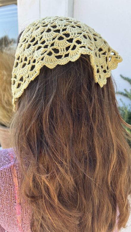 Person wearing a yellow crochet headband with blurred background for the wildest fig crochet collection