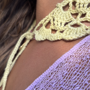 Close-up of a yellow crochet top with a blurred background for the wildest fig crochet collection f