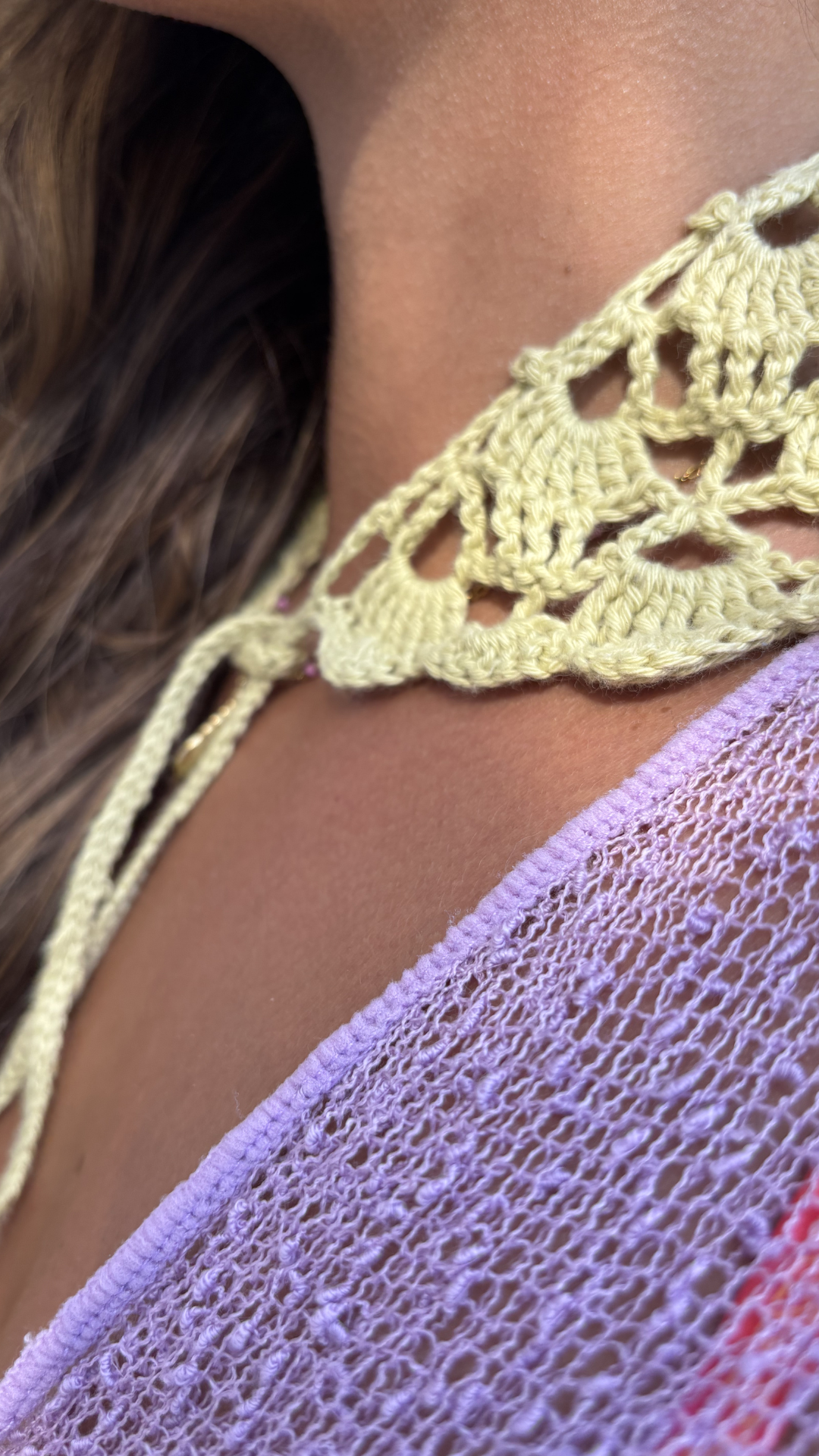 Close-up of a yellow crochet top with a blurred background for the wildest fig crochet collection f