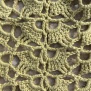Close-up of a sage green crochet pattern of a bandana on a textured surface for the summer 2026 crochet collection of the wildest fig. made in portugal