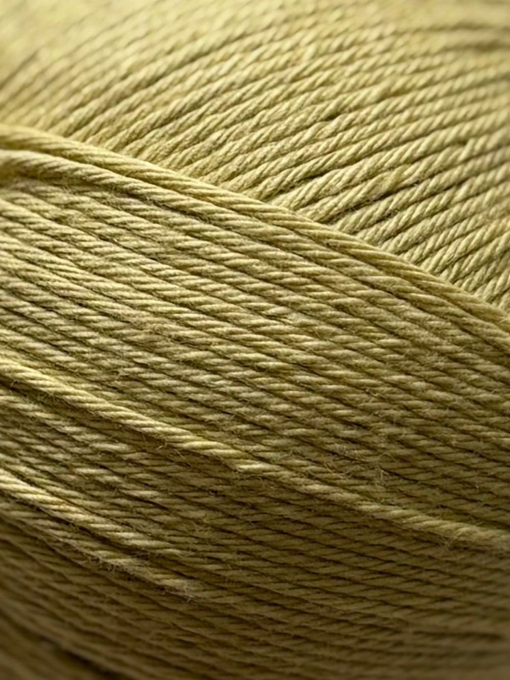 Ball of yellow yarn on a white fabric background. yellow natural silk fiber for crochet collection of the wildest fig