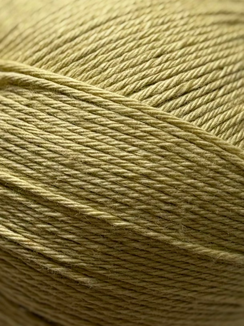 Ball of yellow yarn on a white fabric background. yellow natural silk fiber for crochet collection of the wildest fig